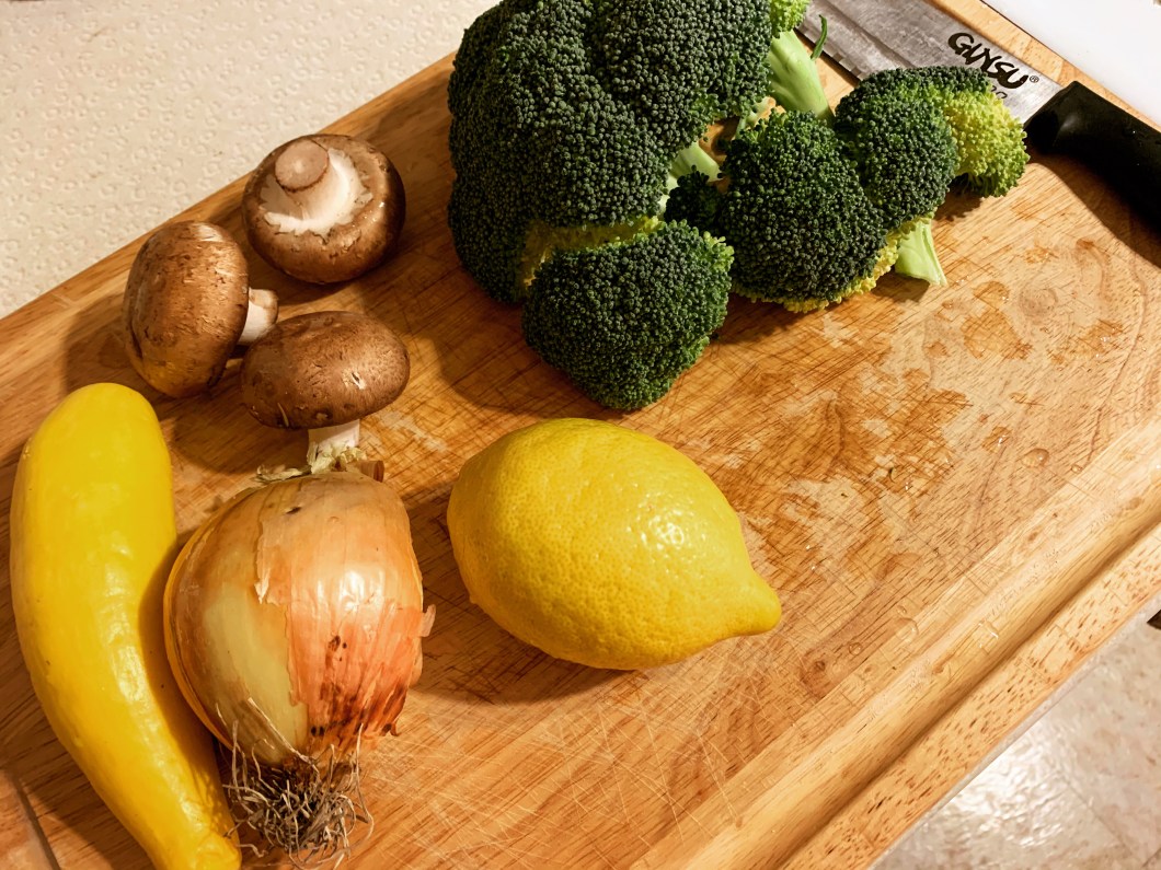 fresh ingredients like broccoli, mushrooms, yellow squash, onions, and lemons.